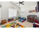 Vibrant bedroom with playful decor, a ceiling fan, a crib, and a table for creative activities at 5456 E Woodridge Dr, Scottsdale, AZ 85254
