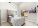 Cozy bedroom with a tufted headboard, decorative pillows, and a mounted television near a window at 5456 E Woodridge Dr, Scottsdale, AZ 85254