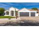 Charming single-story home with a three-car garage, desert landscaping, and a bright, welcoming facade at 5456 E Woodridge Dr, Scottsdale, AZ 85254