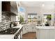 Well-lit kitchen featuring stainless steel appliances, white cabinetry, and tiled backsplash at 5456 E Woodridge Dr, Scottsdale, AZ 85254