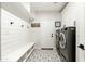 Well-organized laundry room with patterned tile floors, white cabinetry, shelving, and modern appliances at 5456 E Woodridge Dr, Scottsdale, AZ 85254