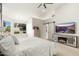 Spacious main bedroom featuring a ceiling fan, large windows, and a media center with an electric fireplace at 5456 E Woodridge Dr, Scottsdale, AZ 85254