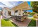 Spacious outdoor bar area with bar seating, built in grill, outdoor TVs, and a view of the pool at 5456 E Woodridge Dr, Scottsdale, AZ 85254