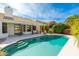 Backyard pool with steps, surrounded by lush landscaping and a spacious patio area, perfect for relaxation and entertainment at 5456 E Woodridge Dr, Scottsdale, AZ 85254