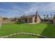 Large backyard with lush lawn, patio, and mature trees providing shade at 6010 E Greenway Ln, Scottsdale, AZ 85254