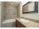 Bathroom boasting a tiled shower, granite counter, and a framed mirror above the sink at 6010 E Greenway Ln, Scottsdale, AZ 85254