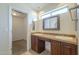 Bright bathroom with double sinks, dark wood cabinets, and neutral-toned flooring at 6010 E Greenway Ln, Scottsdale, AZ 85254