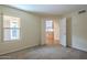 Cozy carpeted bedroom with a window offering natural light and a glimpse of the kitchen at 6010 E Greenway Ln, Scottsdale, AZ 85254