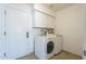 Well-lit laundry room with a new washer and dryer and ample storage cabinets at 6010 E Greenway Ln, Scottsdale, AZ 85254