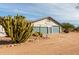 Inviting view of a home's front exterior and the desert landscaping, complemented by a three-car garage at 6404 S Lazy Ln, Gold Canyon, AZ 85118