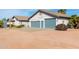 Charming house with blue garage doors, desert landscaping, and bright natural light at 6404 S Lazy Ln, Gold Canyon, AZ 85118