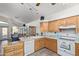 Bright kitchen with wood cabinets, tile flooring, and view to dining area at 6404 S Lazy Ln, Gold Canyon, AZ 85118