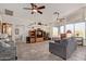 Bright living room featuring tile floors, a ceiling fan, and large windows at 6404 S Lazy Ln, Gold Canyon, AZ 85118
