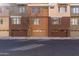 A street view of multi-story townhomes, each with its own garage and unique exterior paint at 6605 N 93Rd Ave # 1022, Glendale, AZ 85305