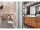 View of a bathroom with warm-toned wooden cabinets and mirrors from an adjacent bedroom at 9183 W Foothill Dr, Peoria, AZ 85383