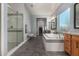 Bright bathroom with a glass shower, a large bathtub, double vanity and a big window at 9183 W Foothill Dr, Peoria, AZ 85383