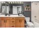 Bathroom featuring a tub with a white shower, wood-look cabinets, and gray accent wall at 9183 W Foothill Dr, Peoria, AZ 85383