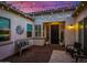 Charming front courtyard with brick pavers, decorative windmill, cozy bench, and a welcoming front door with string lights at 9183 W Foothill Dr, Peoria, AZ 85383