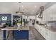 Bright kitchen offers a stone countertop island, white cabinetry, and stainless steel appliances at 9183 W Foothill Dr, Peoria, AZ 85383