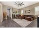 Spacious living room is complete with wood floors, oversized fan, and a large sectional couch at 9183 W Foothill Dr, Peoria, AZ 85383