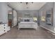 Well-lit primary bedroom with a sliding barn door to the ensuite bath, light gray walls, and neutral carpeting at 9183 W Foothill Dr, Peoria, AZ 85383