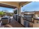 Outdoor kitchen featuring a built-in grill, beverage center, and bar seating for entertaining guests at 9183 W Foothill Dr, Peoria, AZ 85383