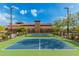 Close up of a pristine pickleball court with professional net, set against a scenic backdrop of trees and community building at 9183 W Foothill Dr, Peoria, AZ 85383