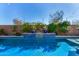 Swimming pool with custom tile and lighting, surrounded by lush landscaping at 9183 W Foothill Dr, Peoria, AZ 85383