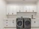 Laundry room with washer, dryer, white countertops, sink, and sleek black fixtures at 9357 W Canyon Verde Dr, Casa Grande, AZ 85194