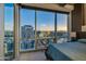 Bedroom boasts stunning city views through expansive windows, complemented by a comfortable bed at 1 E Lexington Ave # 1211, Phoenix, AZ 85012