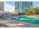 Community pool area with lounge chairs, palm trees, and a building exterior at 1 E Lexington Ave # 1211, Phoenix, AZ 85012