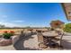 Outdoor patio with chairs and table overlooking a grassy area at 11265 E Laguna Azul Cir, Mesa, AZ 85209