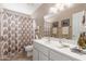 Well-lit bathroom showcasing a white vanity, framed mirror, and shower with decorative curtain at 11265 E Laguna Azul Cir, Mesa, AZ 85209