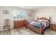 Cozy bedroom with wood-look floors, a decorative quilt, and a bright window with plantation shutters at 11265 E Laguna Azul Cir, Mesa, AZ 85209