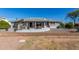 Back exterior showing patio, green space, desert landscaping, and neutral color scheme at 11265 E Laguna Azul Cir, Mesa, AZ 85209