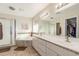 Bathroom featuring double sinks, a large mirror, and a separate shower and bathtub at 11265 E Laguna Azul Cir, Mesa, AZ 85209