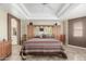 Main bedroom with a tray ceiling, mirrored built-ins, and a view to the ensuite bathroom at 11265 E Laguna Azul Cir, Mesa, AZ 85209