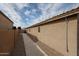 Side exterior view of a property featuring a walkway, stucco walls, and drought-resistant landscaping at 12622 W Avalon Dr, Avondale, AZ 85392