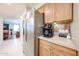 Kitchen area with stainless steel refrigerator, wooden cabinets, granite countertops, and a coffee station at 12622 W Avalon Dr, Avondale, AZ 85392