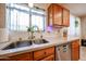 Close-up of a kitchen sink with wooden cabinets, granite countertops, and stainless steel appliances at 12622 W Avalon Dr, Avondale, AZ 85392