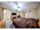 Carpeted main bedroom with a fireplace, ceiling fan, dresser, and door leading to an ensuite bathroom at 12622 W Avalon Dr, Avondale, AZ 85392