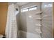 Bright and spacious bathroom featuring tiled shower over tub and unique shelving at 12622 W Avalon Dr, Avondale, AZ 85392