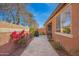 Backyard area with flowers along block fence and a paved path and grill at 13108 N 91St N Ln, Peoria, AZ 85381