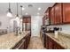 Spacious kitchen featuring dark cabinets, stainless steel appliances, granite countertops, and a sink in the island at 13108 N 91St N Ln, Peoria, AZ 85381