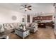 Comfortable living room with open layout flowing into kitchen, tile floors and a ceiling fan at 13108 N 91St N Ln, Peoria, AZ 85381