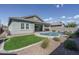 Beautiful backyard with a pool, travertine tile, and synthetic grass at 15233 W Baden St, Goodyear, AZ 85338