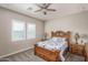 Cozy bedroom featuring a wooden bed frame, plush carpet, and dual windows for ample natural light at 15233 W Baden St, Goodyear, AZ 85338