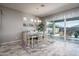 Bright dining area with wood flooring, a stylish chandelier, and sliding glass doors to the backyard pool at 15233 W Baden St, Goodyear, AZ 85338