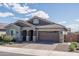 Charming exterior showcases a well-maintained lawn, manicured shrubs, and a paved driveway to the attached garage at 15233 W Baden St, Goodyear, AZ 85338