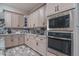 Close up of kitchen with stainless steel microwave and oven, granite countertops and wood cabinets at 15233 W Baden St, Goodyear, AZ 85338